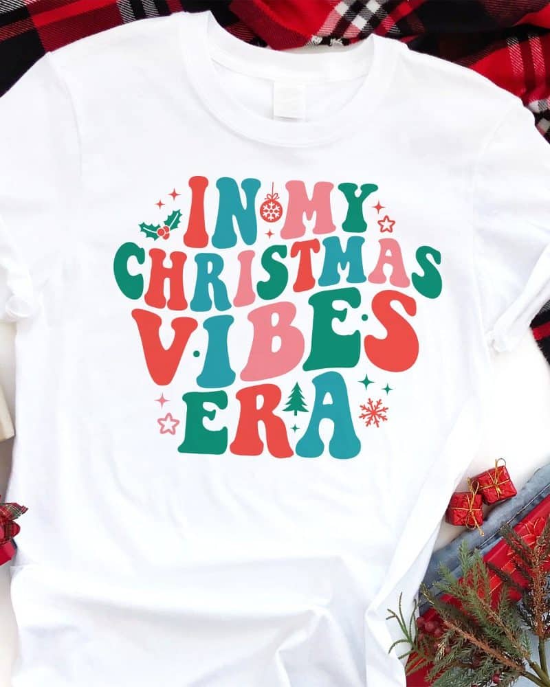 White t-shirt with colorful retro-style text reading In My Christmas Vibes Era.
