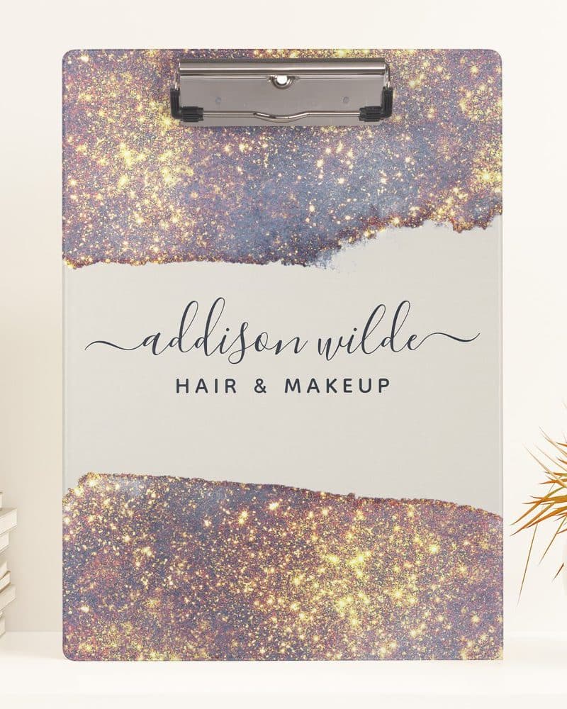 A clipboard with a sparkly, gold and purple design and the name Addison Wilde Hair & Makeup.