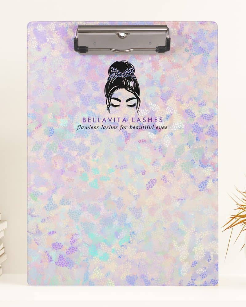 A pastel-colored clipboard with a logo featuring a woman's face and the words Bellavita Lashes.