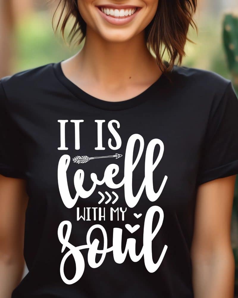 Woman wearing a black t-shirt with the phrase It Is Well With My Soul in white lettering. An arrow is included in the design.