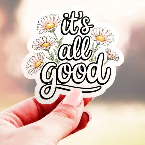 Hand Holding A Sticker That Says It'S All Good, Surrounded By Daisies.