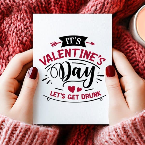 Two Hands Hold A Valentines Day Card That Says, Its Valentines Day, Lets Get Drunk.