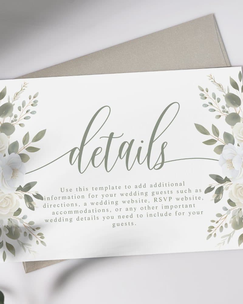 Wedding details card with white flowers and green leaves.