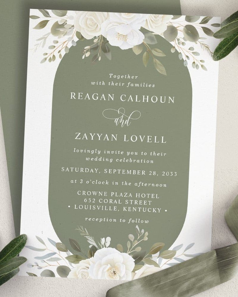 Wedding invitation for Reagan Calhoun and Zayyan Lovell, featuring white flowers and sage green accents.