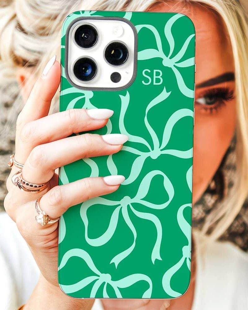 Woman's hand holding a teal iPhone case with a light teal bow pattern.
