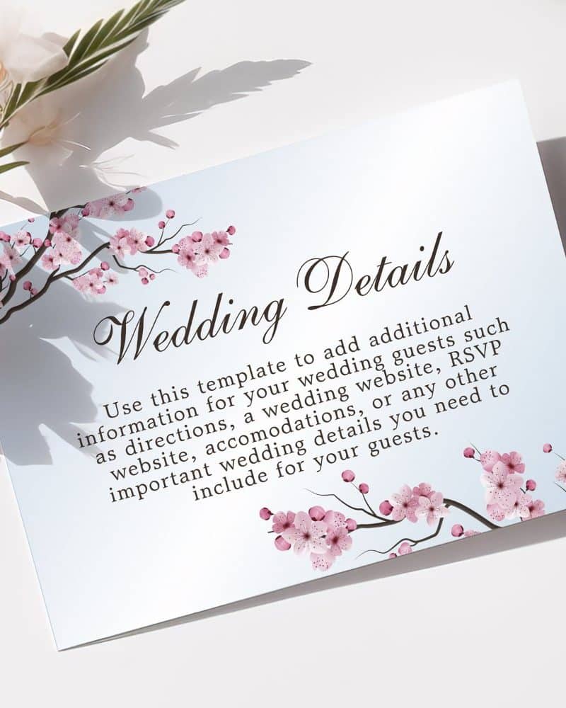 Wedding details card with pink cherry blossoms.