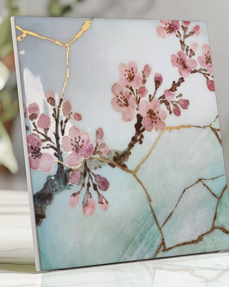 Square art print featuring a delicate watercolor painting of pink cherry blossoms on a pale blue and green background with gold crackle detailing.
