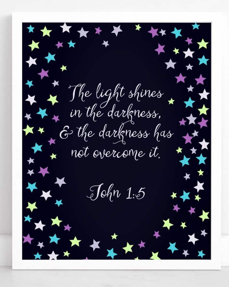 Framed print with John 1:5, "The light shines in the darkness, & the darkness has not overcome it," surrounded by pastel stars on a dark background.