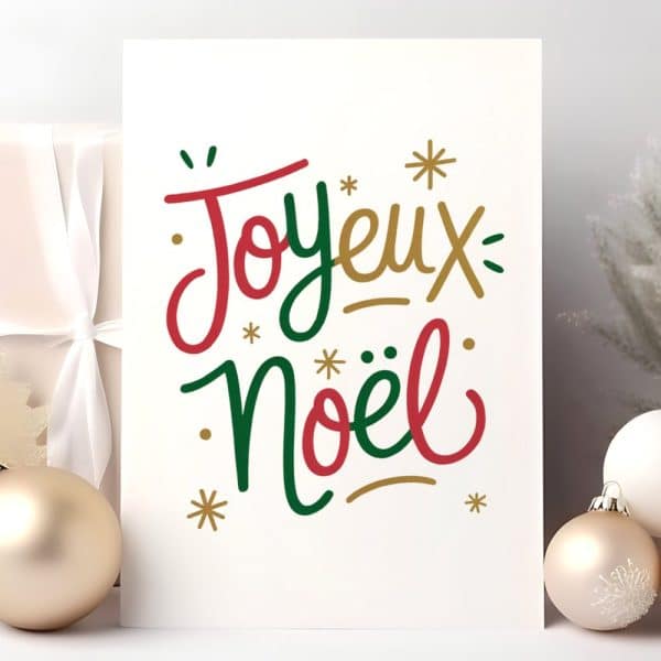 White Card With The French Phrase Joyeux Noël In Stylized Red And Green Lettering.