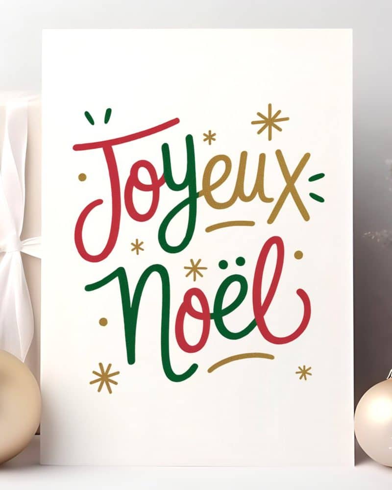 White card with the French phrase Joyeux Noël in stylized red and green lettering.