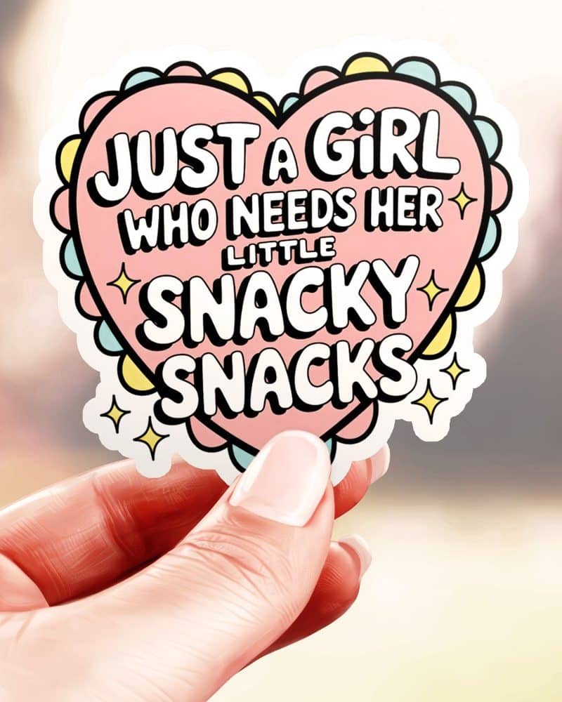 A hand holds a heart-shaped sticker that says, Just a girl who needs her little snaky snacks.