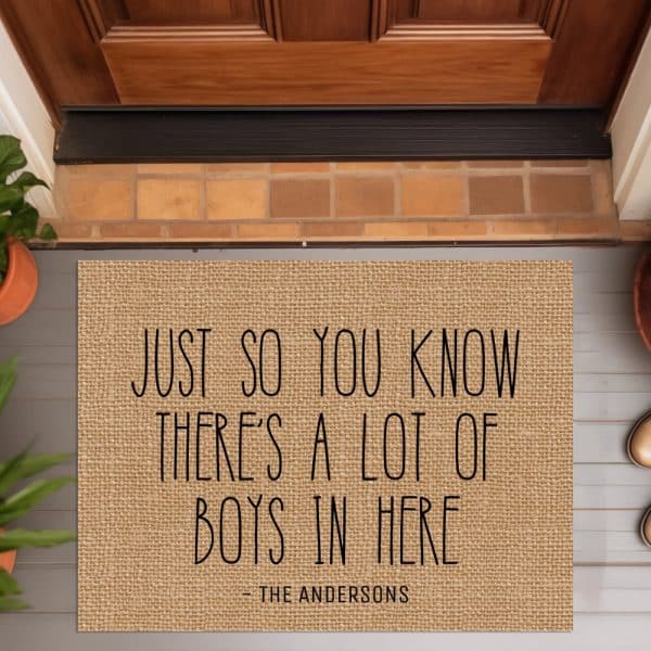 A Tan Burlap Doormat With The Text: Just So You Know There'S A Lot Of Boys In Here, Signed The Andersons.