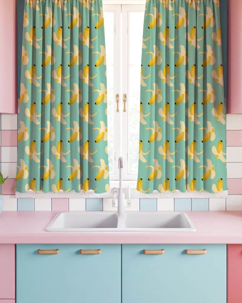 Kitchen window with teal banana-patterned curtains.