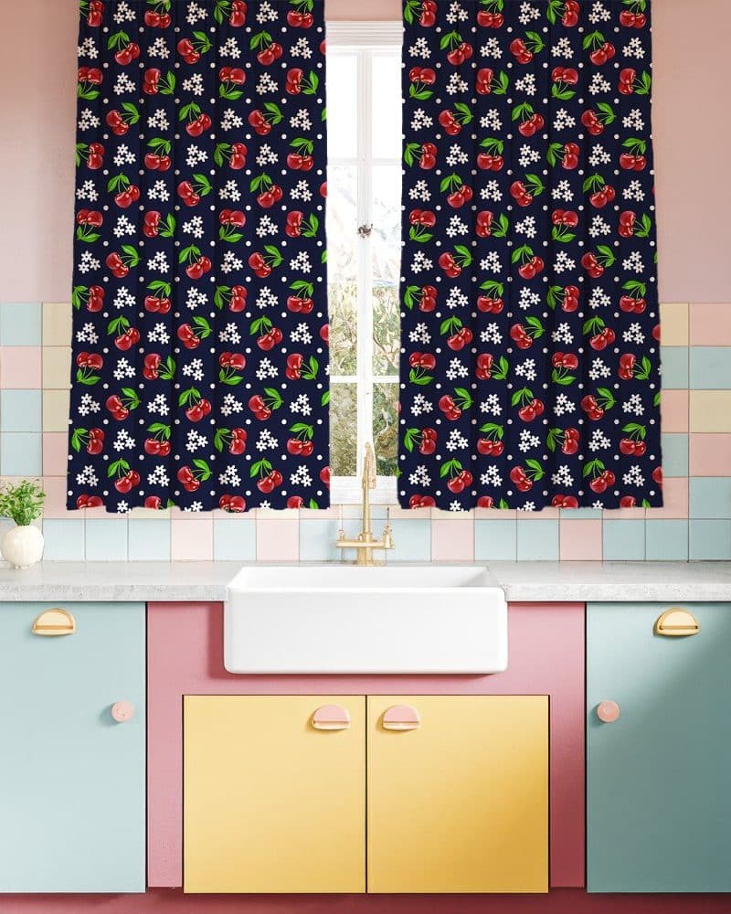 Cherry-printed kitchen curtains hanging on a window.