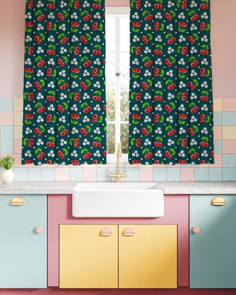 Dark green cherry-print curtains hanging in a retro kitchen.