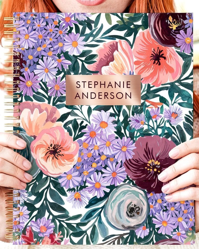 A spiral-bound notebook with a floral design and the name Stephanie Anderson.
