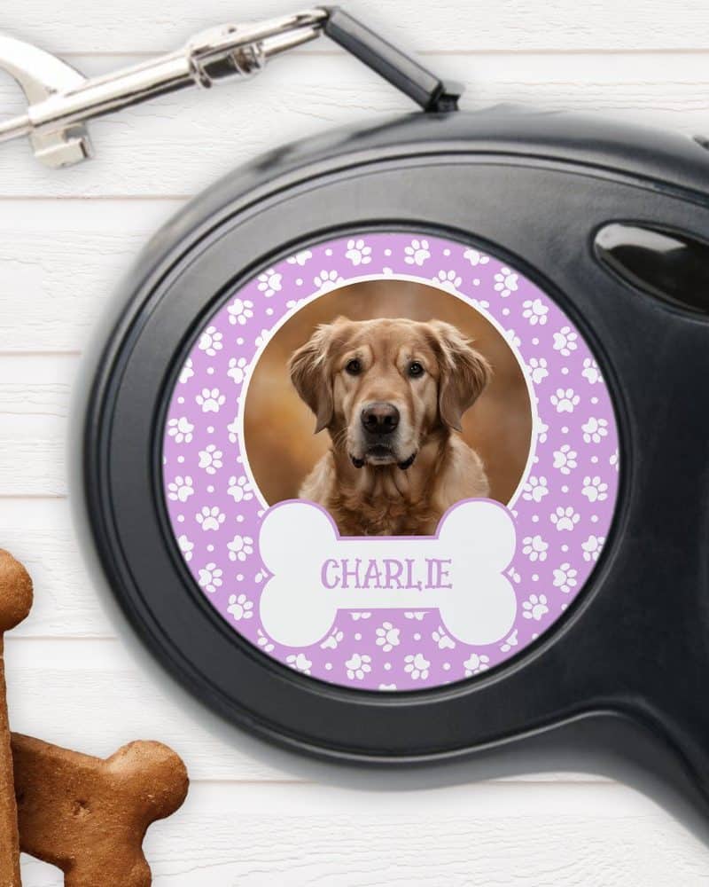 Retractable dog leash with a personalized design featuring a golden retriever's photo, the dog's name Charlie, and paw prints.