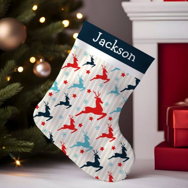 Personalized Christmas Stocking With A Cream Background, Red And Blue Reindeer Pattern, And The Name Jackson.