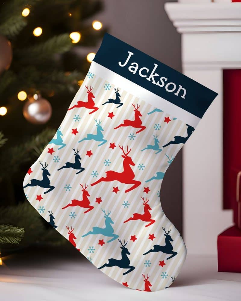 Personalized Christmas stocking with a cream background, red and blue reindeer pattern, and the name Jackson.