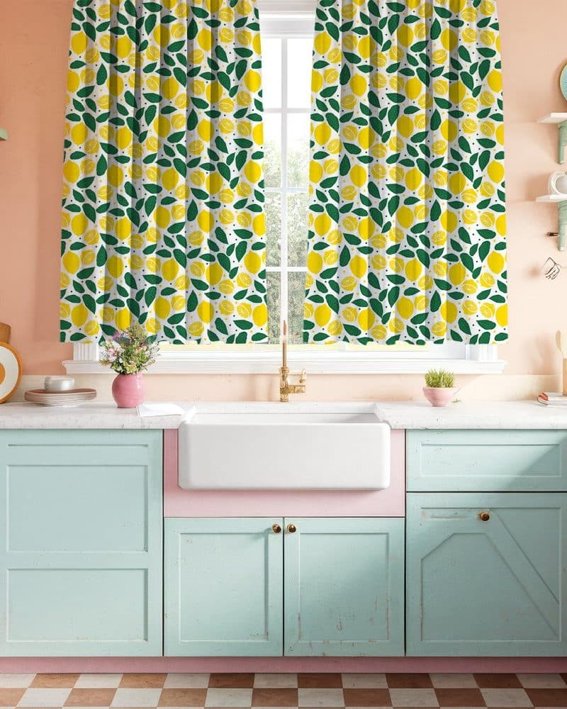 Lemon-patterned kitchen curtains hanging in a pastel kitchen.
