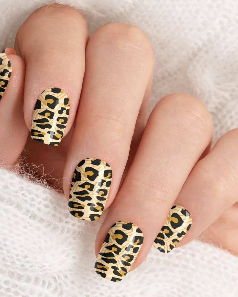 Hand with leopard print nail polish.