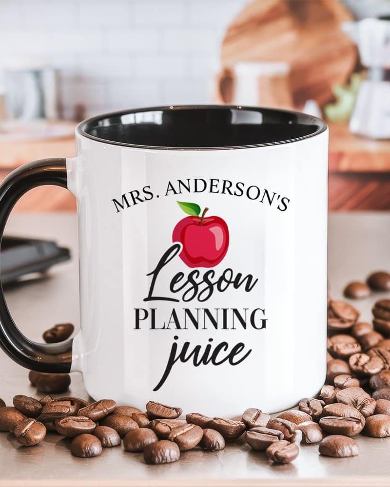 White coffee mug with black handle and rim, displaying the text Mrs. Anderson's Lesson Planning Juice and a red apple graphic.