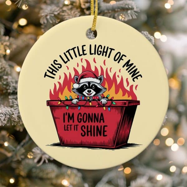 Round Christmas Ornament Featuring A Raccoon Wearing A Santa Hat Inside A Flaming Dumpster Decorated With Christmas Lights. Text Reads, This Little Light Of Mine, I'M Gonna Let It Shine.