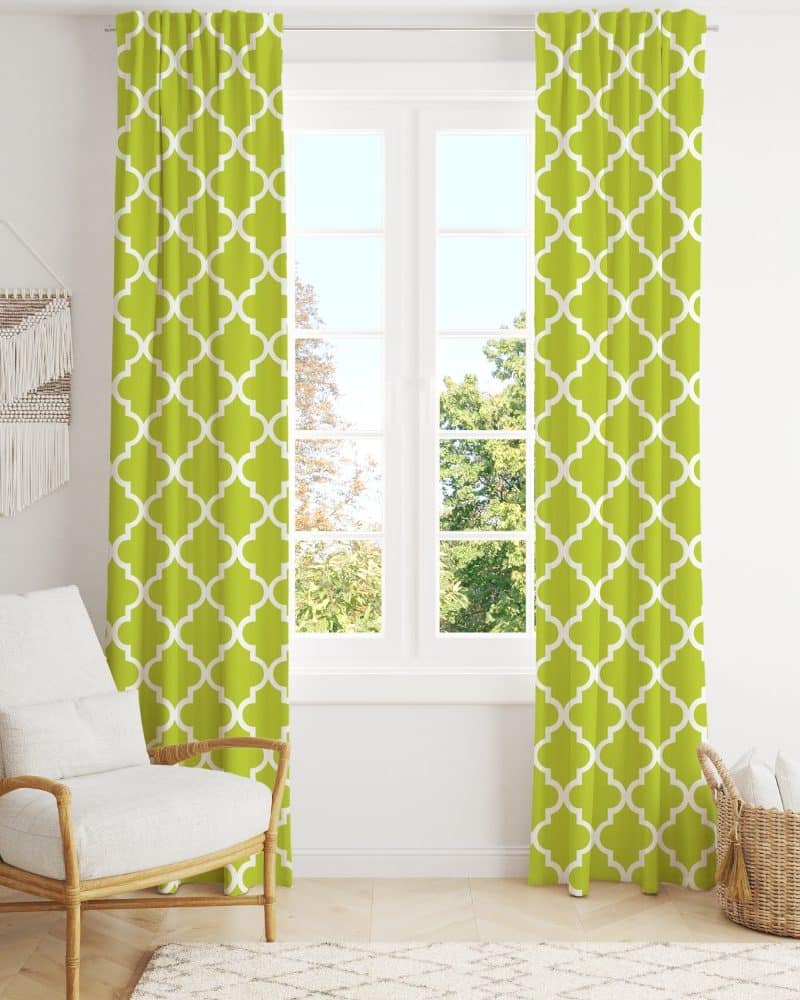 Lime green curtains with a quatrefoil pattern hang on a window.