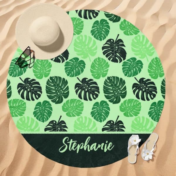 Round Beach Towel With A Light Green Background And A Dark Green Monstera Leaf Pattern; The Name Stephanie Is Printed At The Bottom.