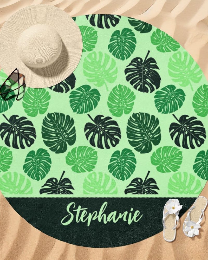 Round beach towel with a light green background and a dark green monstera leaf pattern; the name Stephanie is printed at the bottom.