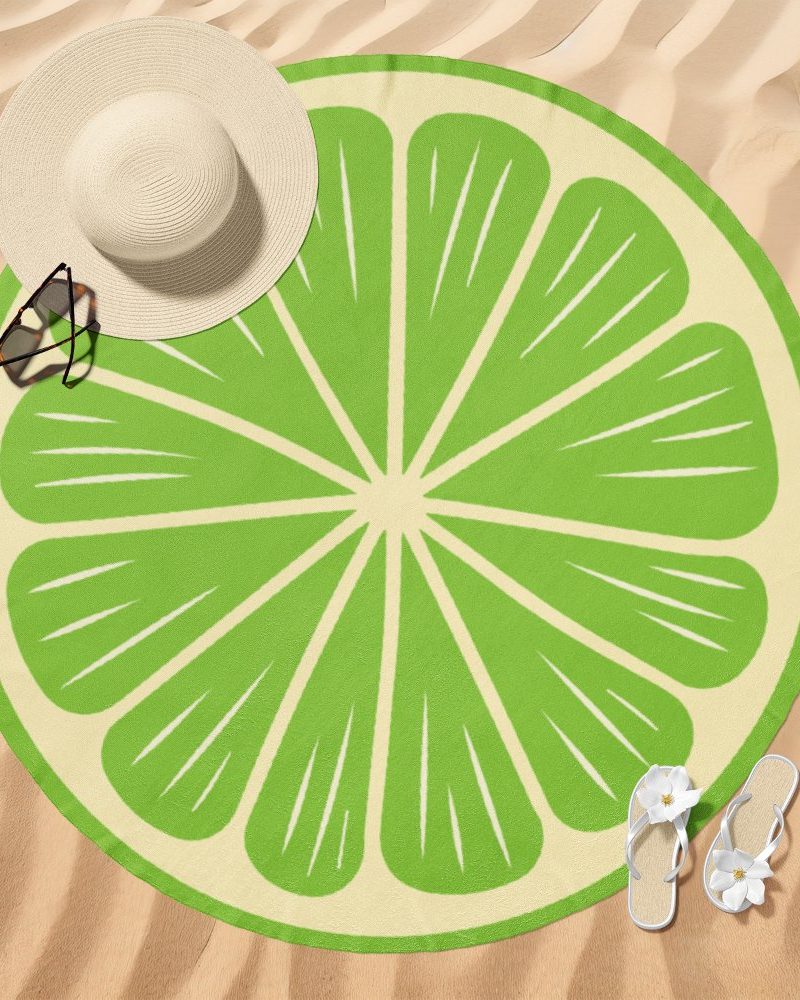 Round lime beach towel on sand.