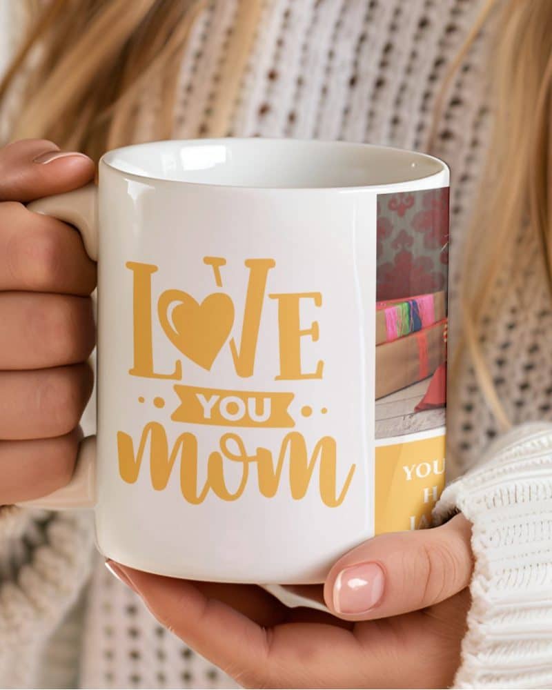 Person holding a white coffee mug with a yellow Love You Mom design and a small photo collage.