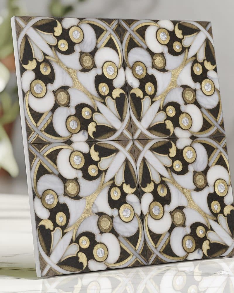 Ornate square tile with a black, white, and gold floral pattern.