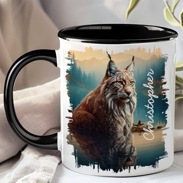 Black-Handled Mug With A Lynx Image; The Lynx Is Brown And Sitting By Water, Reflected In The Water Below. The Name Christopher Is On The Mug.