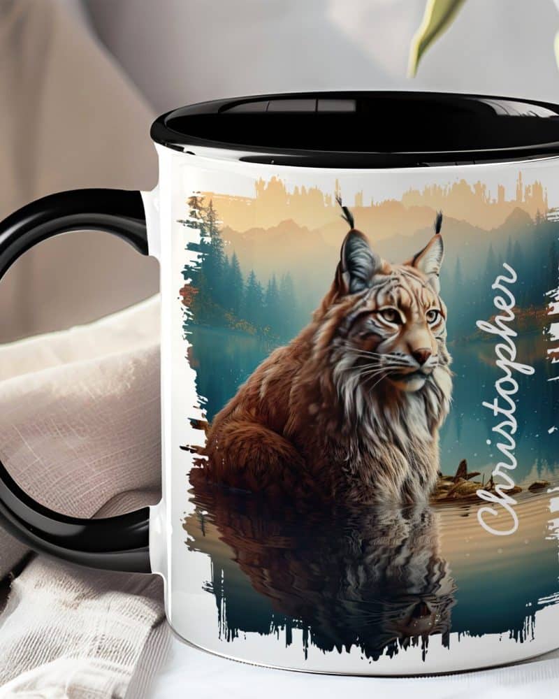Black-handled mug with a lynx image; the lynx is brown and sitting by water, reflected in the water below. The name Christopher is on the mug.
