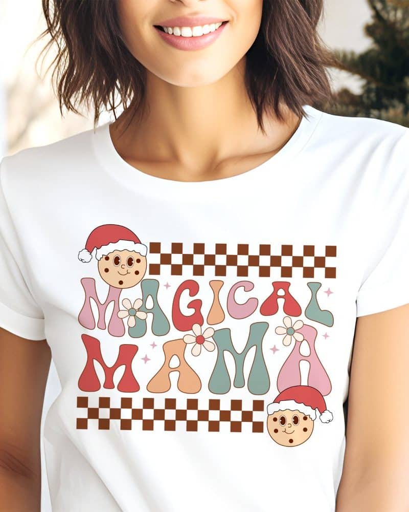 Woman wearing a white t-shirt with a retro design that says Magical Mama and features Christmas cookie illustrations.