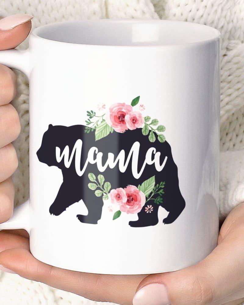 White coffee mug featuring a black bear silhouette adorned with pink flowers and the word Mama.