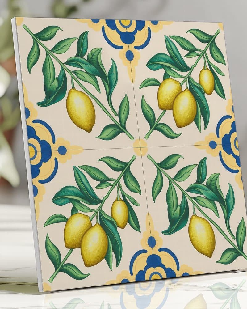 Tile depicting lemon branches with yellow lemons and green leaves on a cream background with blue and yellow floral accents.