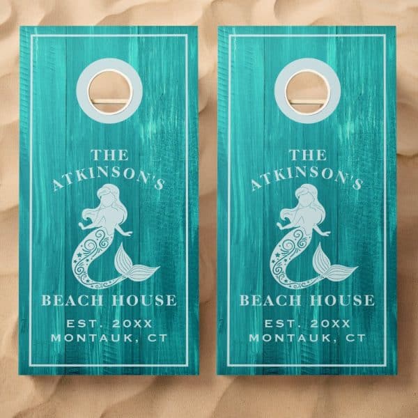 Pair Of Teal Cornhole Boards With A Mermaid Design, Personalized With The Atkinson'S Beach House Name And Location.
