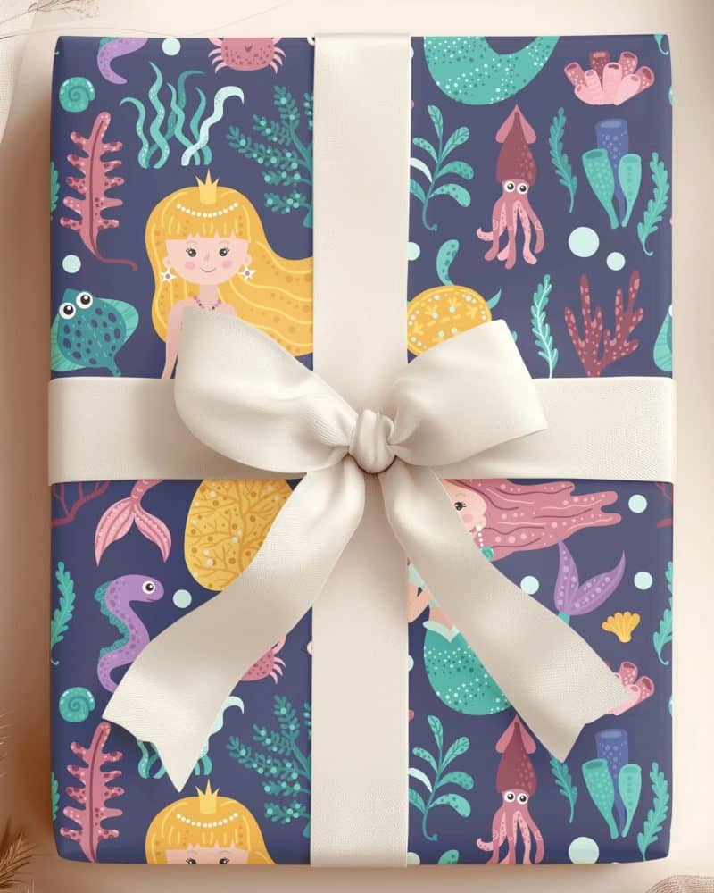 Gift wrapped in mermaid-themed wrapping paper with a cream-colored ribbon.