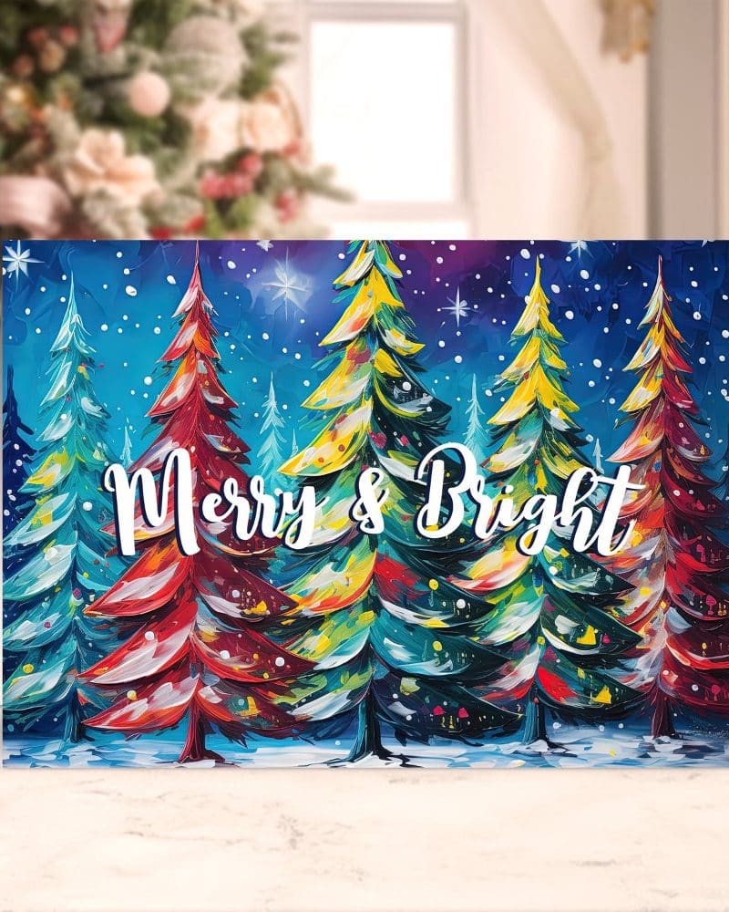 Christmas card depicting a row of colorful, brightly painted Christmas trees against a dark blue night sky with falling snow. The words Merry & Bright are written across the trees.