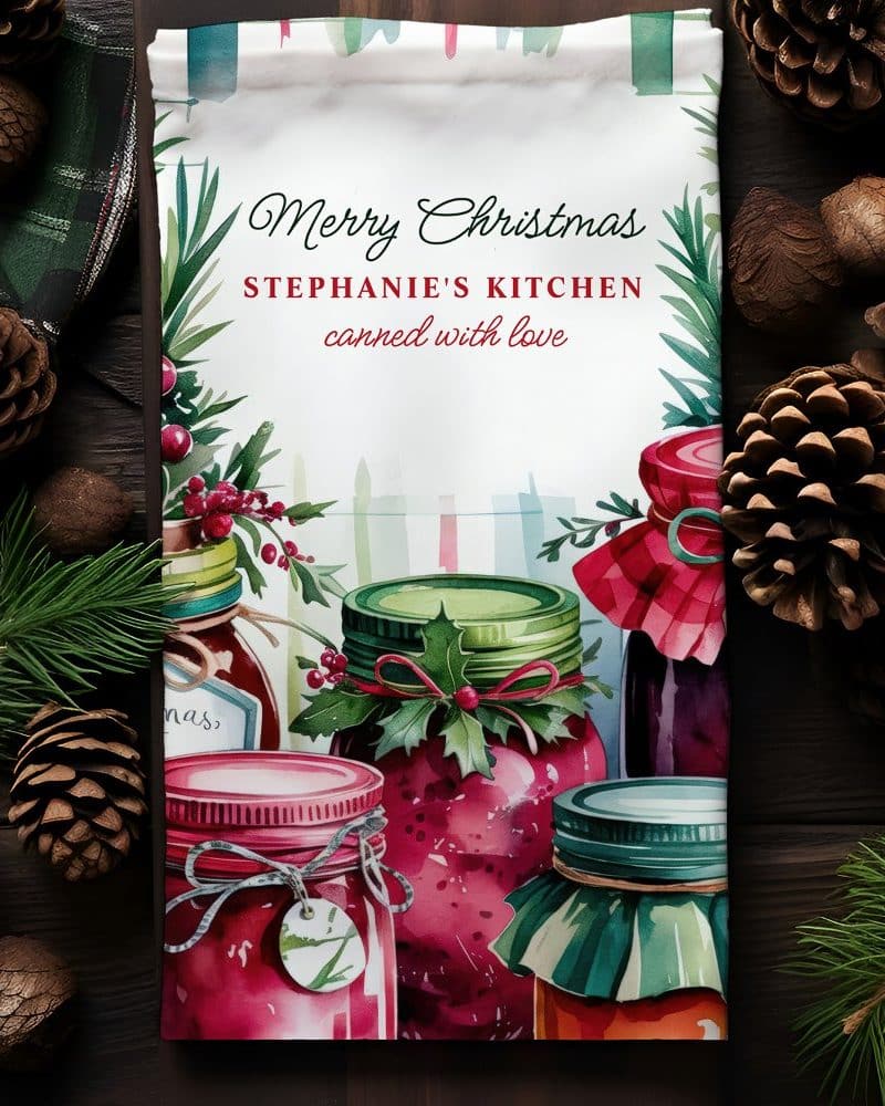 Christmas tea towel featuring watercolor jars of jam, decorated with holly.