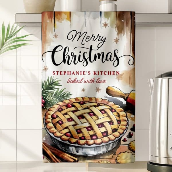 Christmas Kitchen Towel Featuring A Watercolor Illustration Of A Cranberry Pie, Along With The Text Merry Christmas And Stephanies Kitchen Baked With Love.