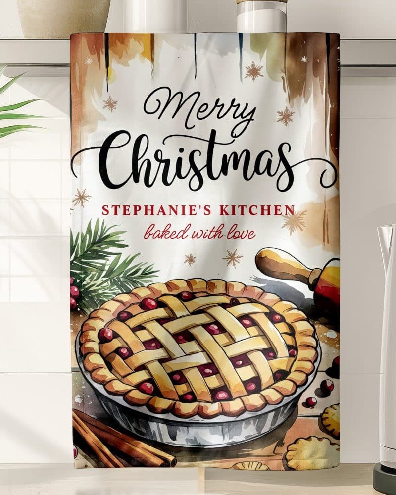 Christmas kitchen towel featuring a watercolor illustration of a cranberry pie, along with the text Merry Christmas and Stephanies Kitchen baked with love.