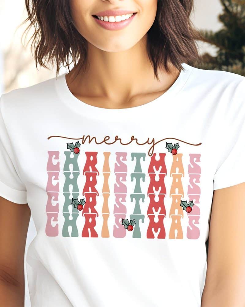 White t-shirt with a retro-style Merry Christmas design in pastel colors and holly berries.