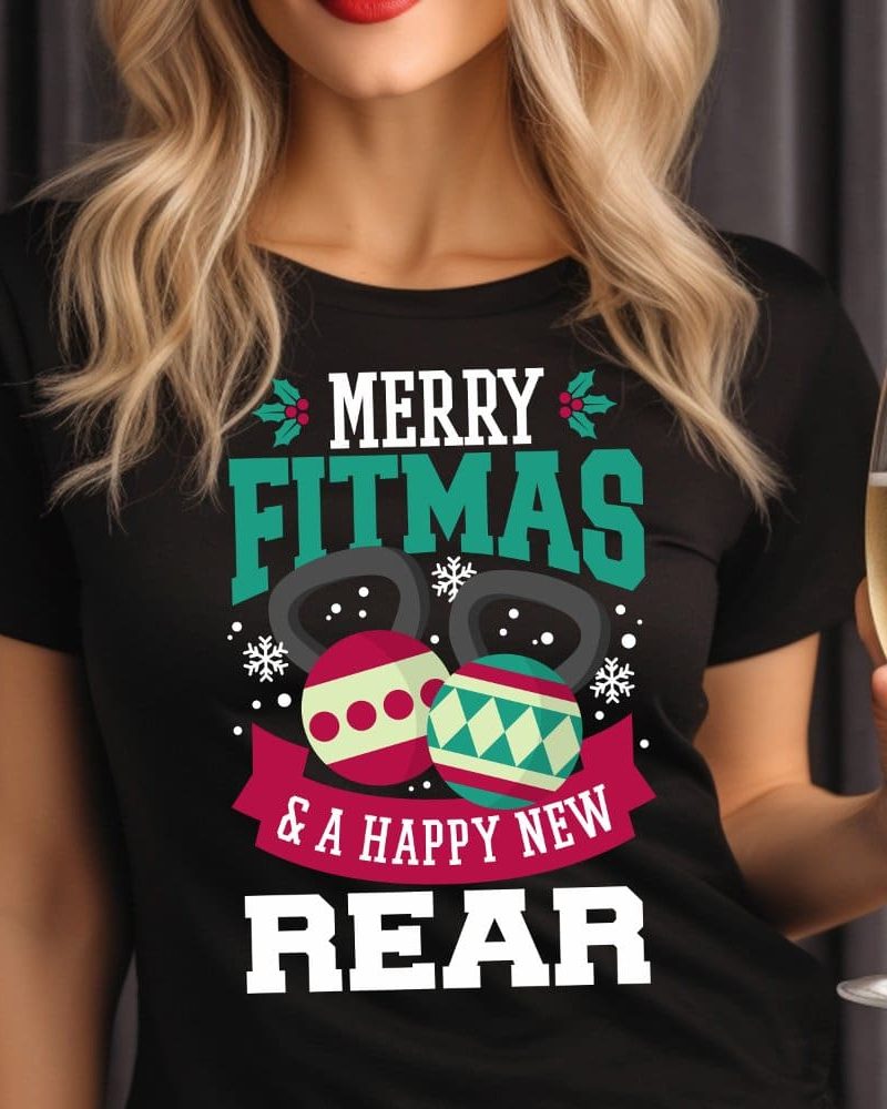 Woman wearing a black t-shirt with a Christmas fitness design. The shirt says Merry Fitmas and a Happy New Rear. Kettlebells decorated as ornaments are featured on the shirt.