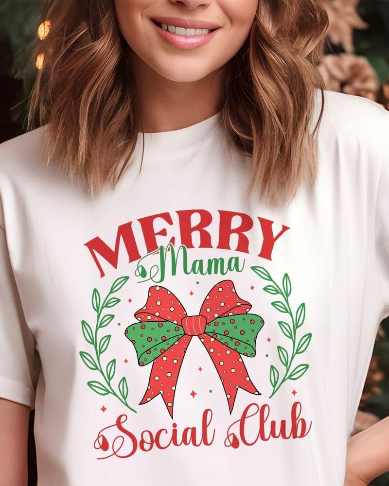 Woman wearing a white t-shirt with a Christmas design that says Merry Mama Social Club and features a red and green bow.