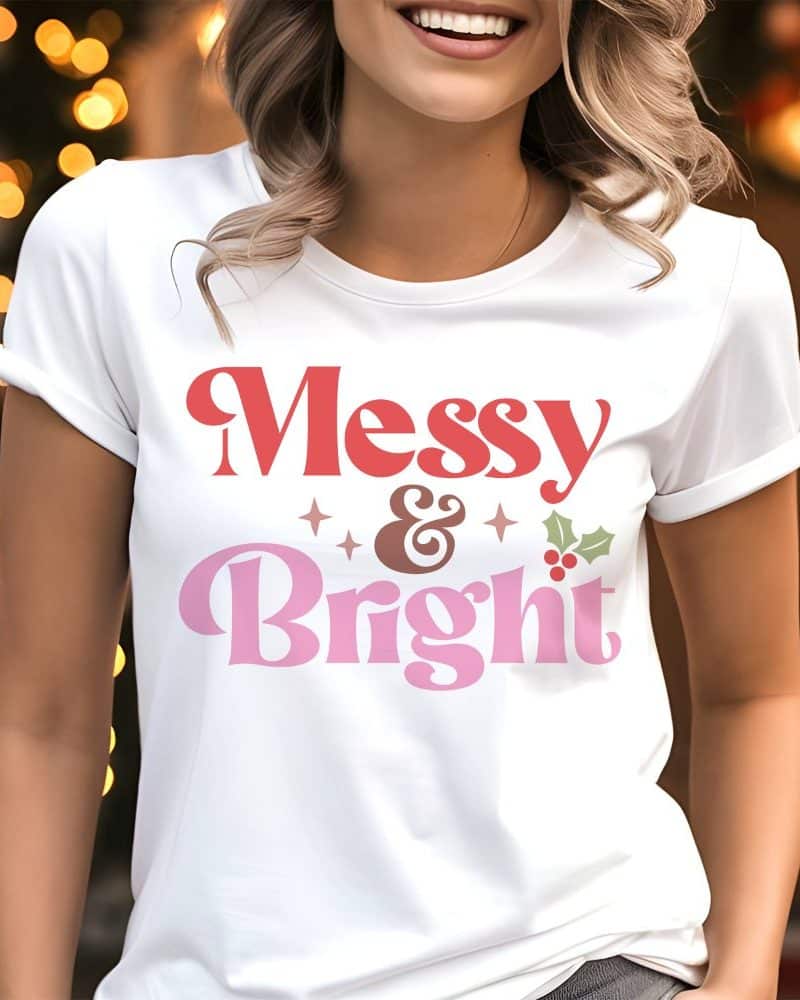Woman wearing a white t-shirt with a Christmas design that says Messy & Bright in retro style lettering.