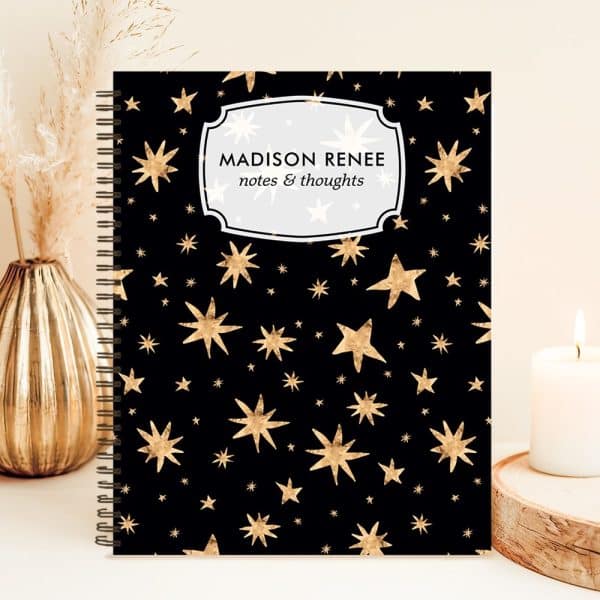Black Spiral Notebook With A Gold Star Pattern And Personalized Name, Madison Renee, On The Cover.