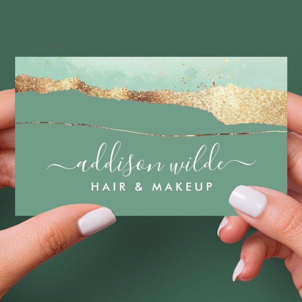 Two Hands Hold Up A Sage Green Business Card With Gold Foil Detailing And The Name Addison Wilde, Hair &Amp; Makeup.